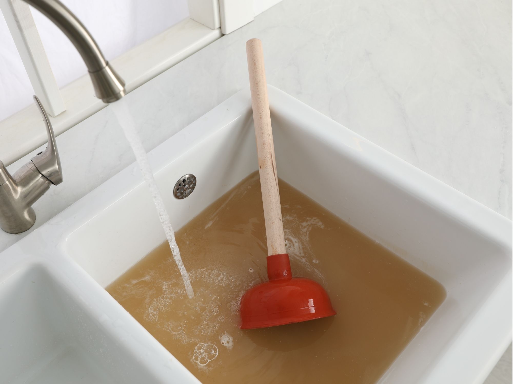 Clogged kitchen sink with backed up dirty water